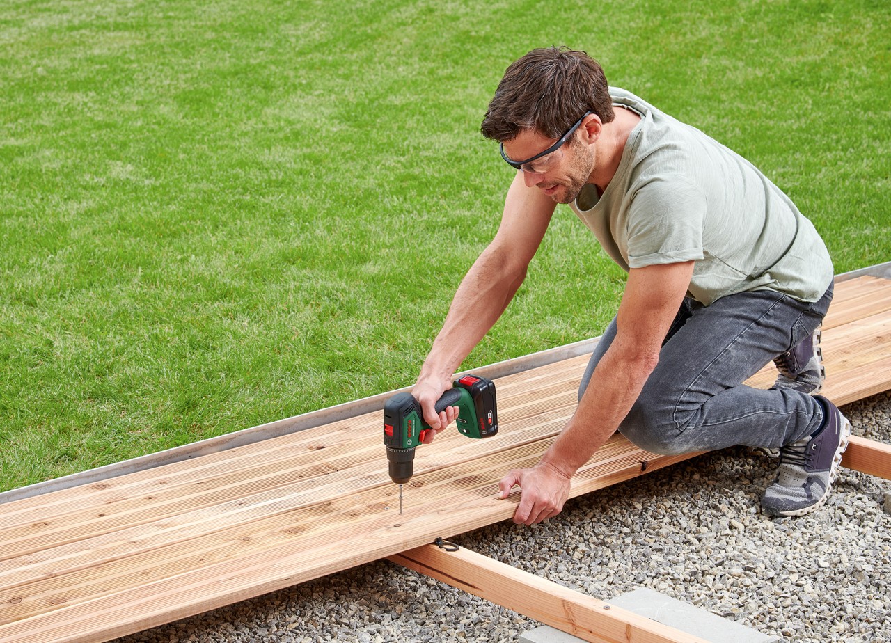 Bosch UniversalDrill 18V-60 beim Verschrauben einer Holzterrasse